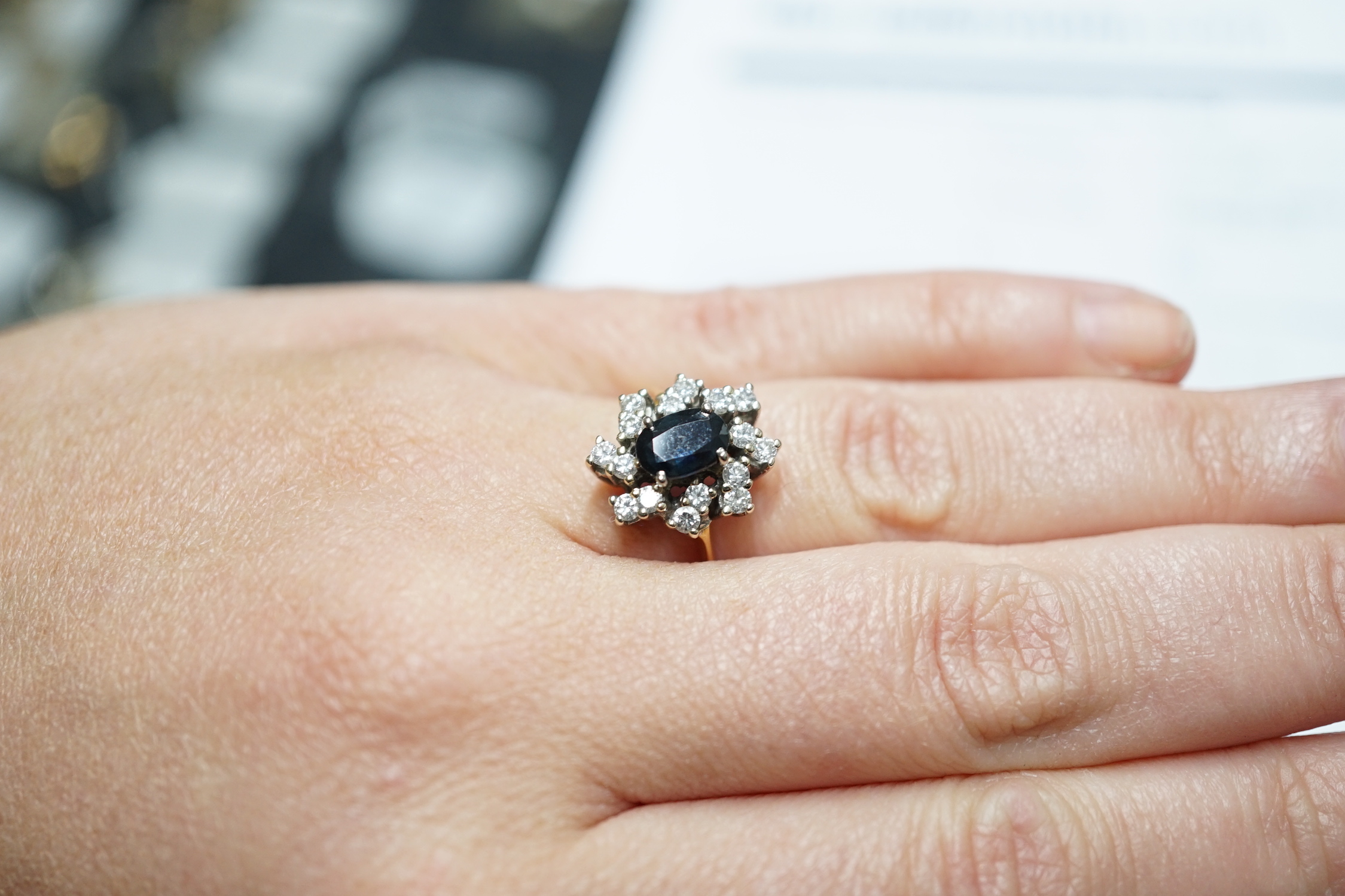 A modern 18ct gold, sapphire and diamond set oval cluster ring, size L, gross weight 4.8 grams.